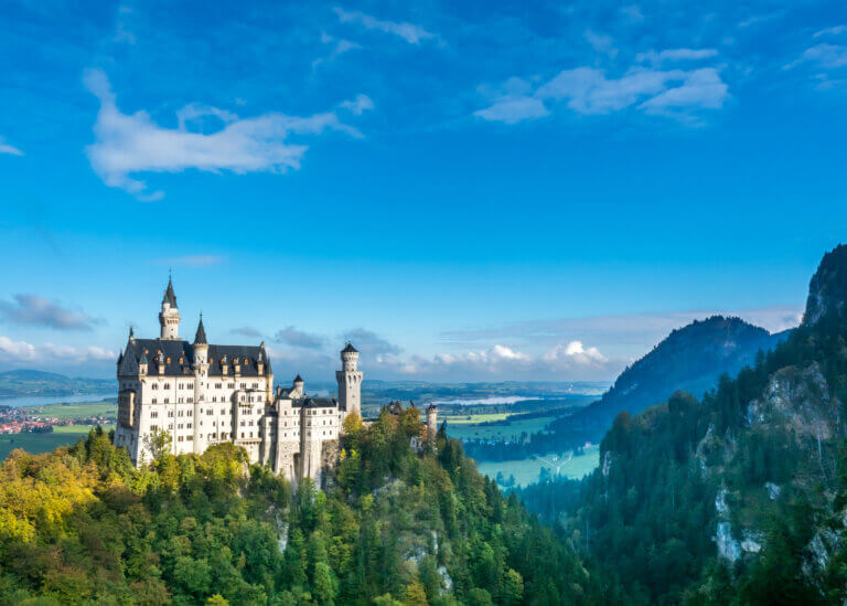 Neuschwanstein Castle in Bavaria, Germany with alpine mountains and panoramic landscape view