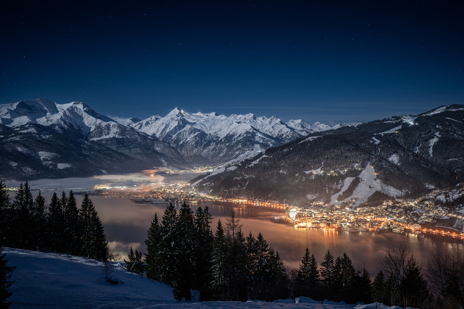 Night view from the Mitterberg over snowy Zell am See and the mountains