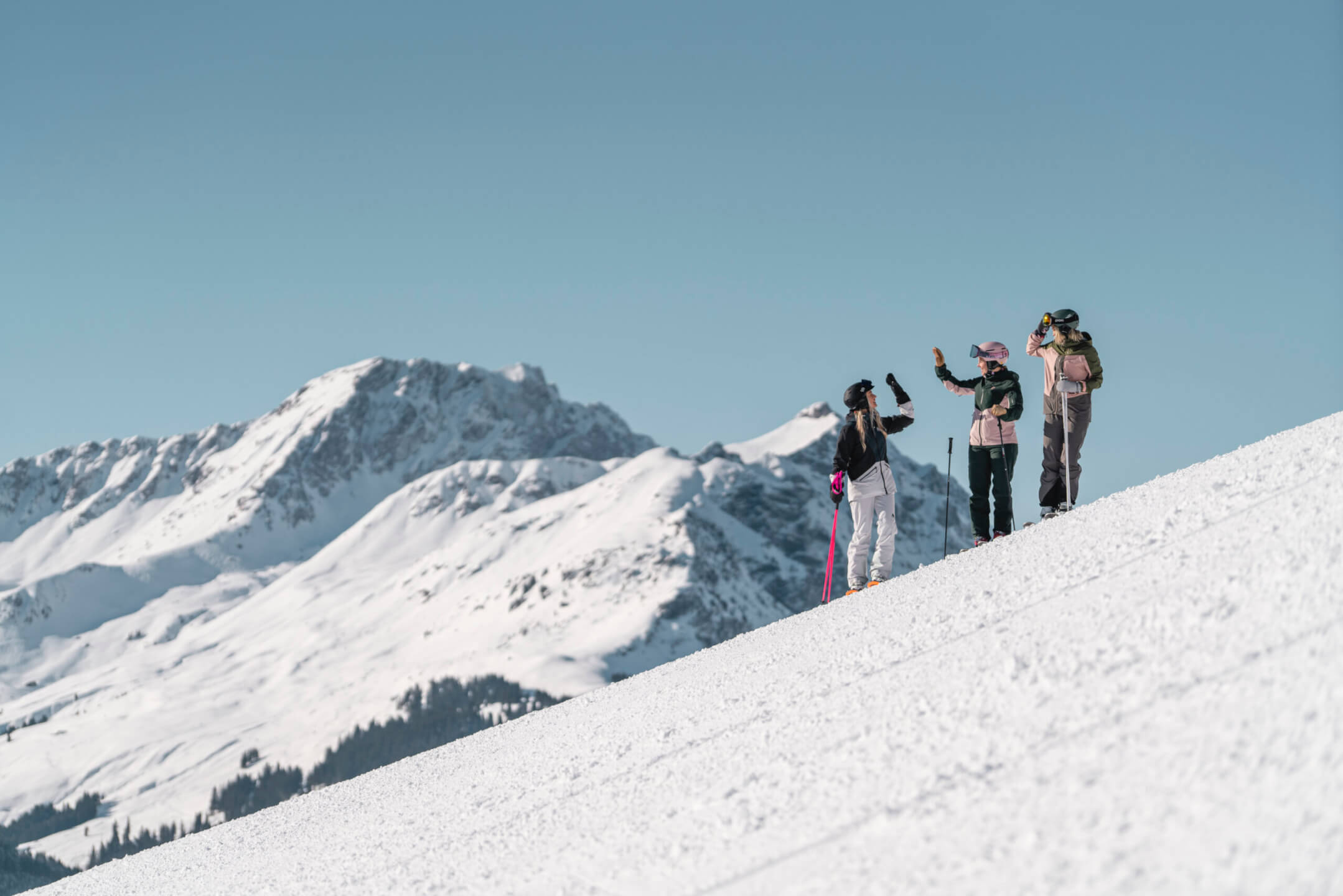 Friends skiing on a sunny slope in the Skicircus Saalbach Hinterglemm