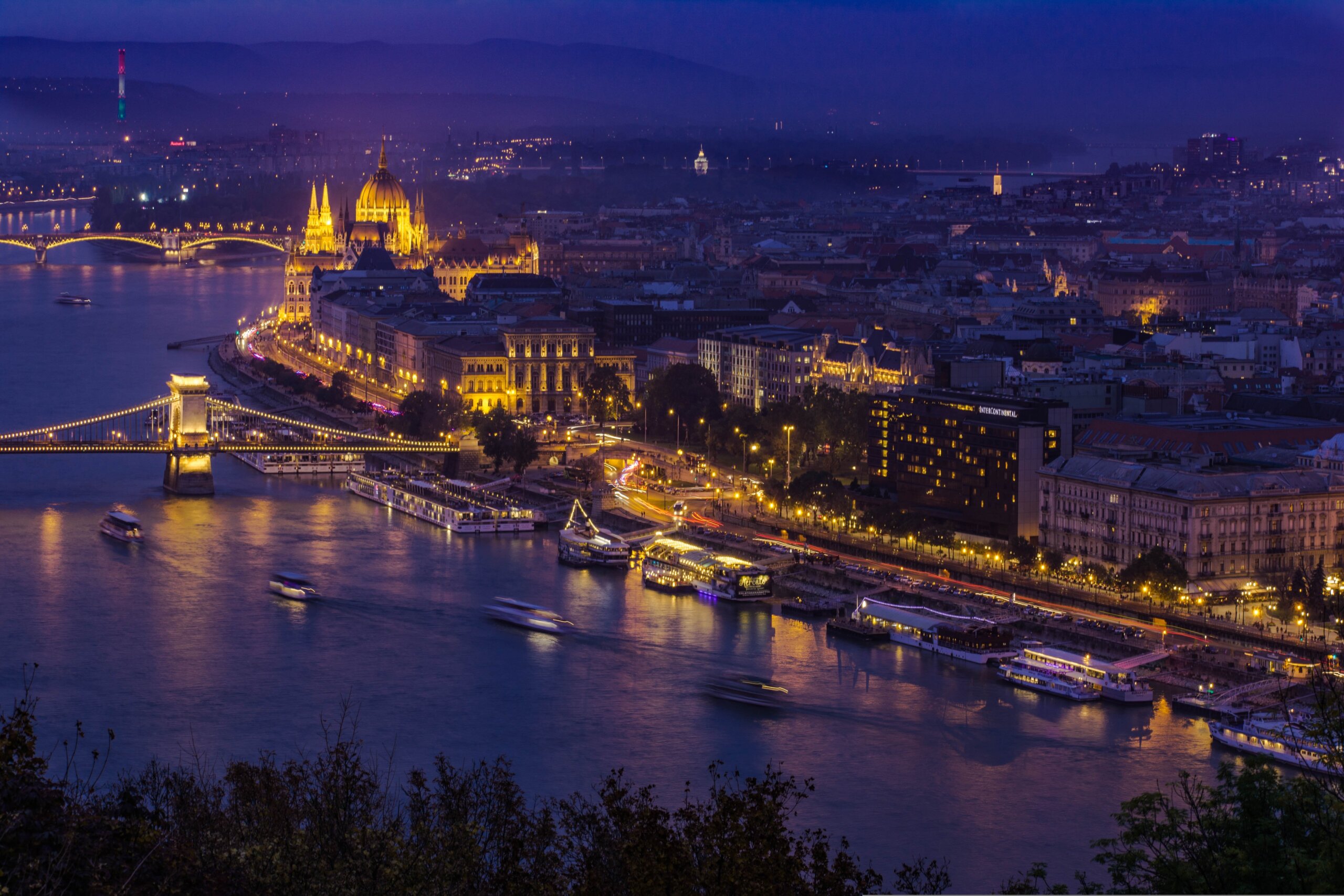 The Hungarian Parliament glowing gold at blue hour above the Danube in Budapest
